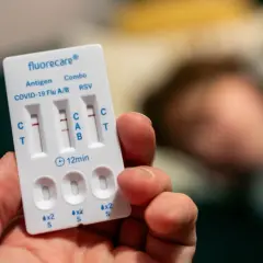 Test na grypę i COVID-19. Dwa paski na teście wskazują pozytywny wynik.