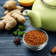Imbir, cytryna, cynamon, miód i zielony dzbanek na niebieskim tle.