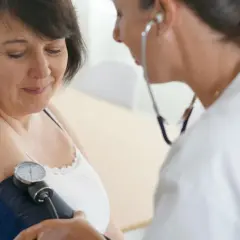 Lekarz mierzy ciśnienie pacjentce za pomocą ciśnieniomierza.
