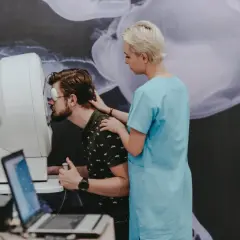 Badanie pola widzenia wykrywa ubytki w zakresie widzenia, pomagając zdiagnozować choroby oczu. Pacjent z zasłoniętym okiem wykonuje test.