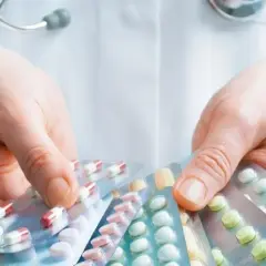 Lekarz pokazuje opakowania tabletek, przypominając o potencjalnych metypred skutki uboczne.