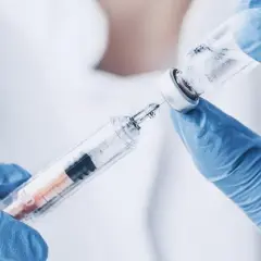 Rękawiczki medyczne pobierają płyn do strzykawki. Przygotowanie do podania szczepionki na pneumokoki.