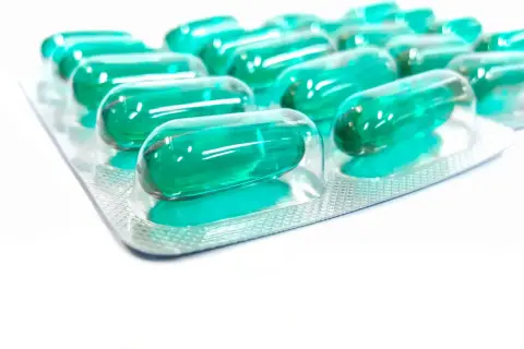 Blister opakowania z zielonymi kapsułkami. Pamiętaj o prawidłowym ibuprofen dawkowanie, by skutecznie złagodzić ból.