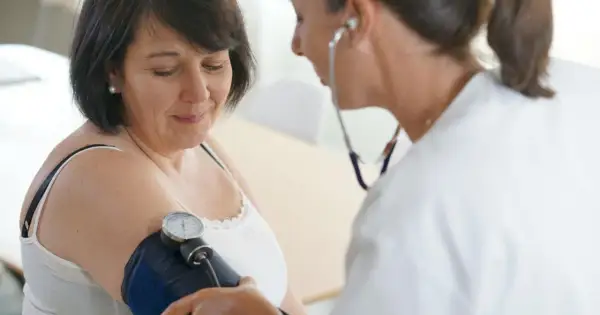 Lekarz mierzy ciśnienie pacjentce za pomocą ciśnieniomierza.