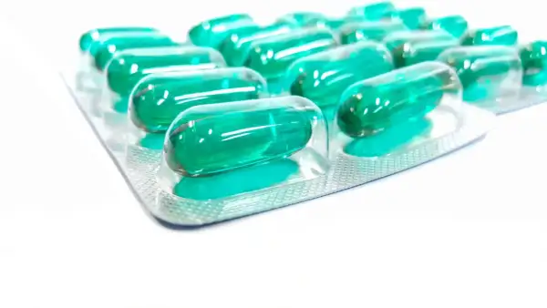 Blister opakowania z zielonymi kapsułkami. Pamiętaj o prawidłowym ibuprofen dawkowanie, by skutecznie złagodzić ból.