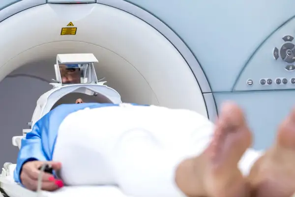 Pacjent leży w aparacie do rezonansu magnetycznego. Widoczne są jego oczy w specjalnym wizjerze, który pomaga jak przetrwać rezonans magnetyczny.